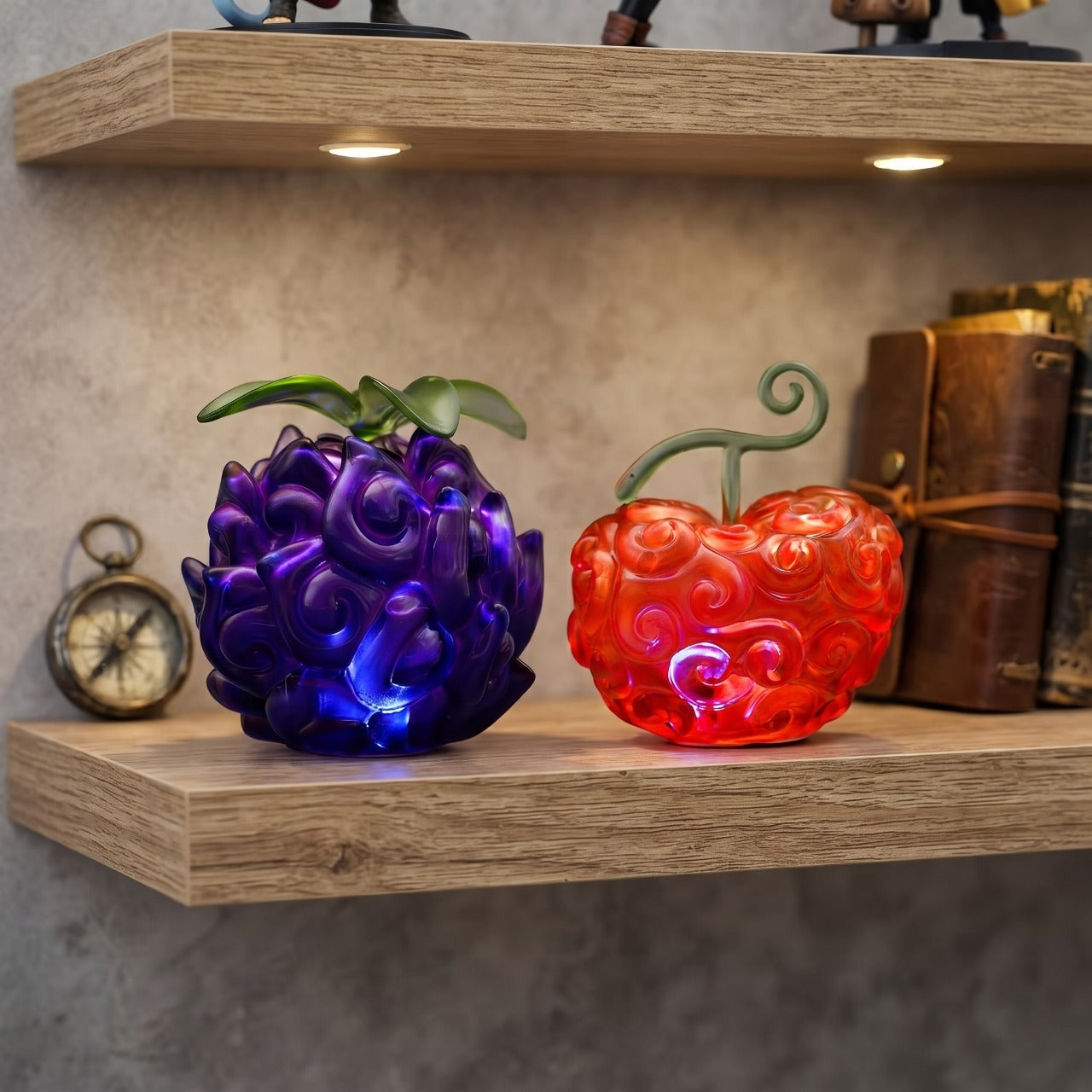 Deux répliques de Fruits du Démon One Piece, violette et rouge, posées sur une étagère en bois